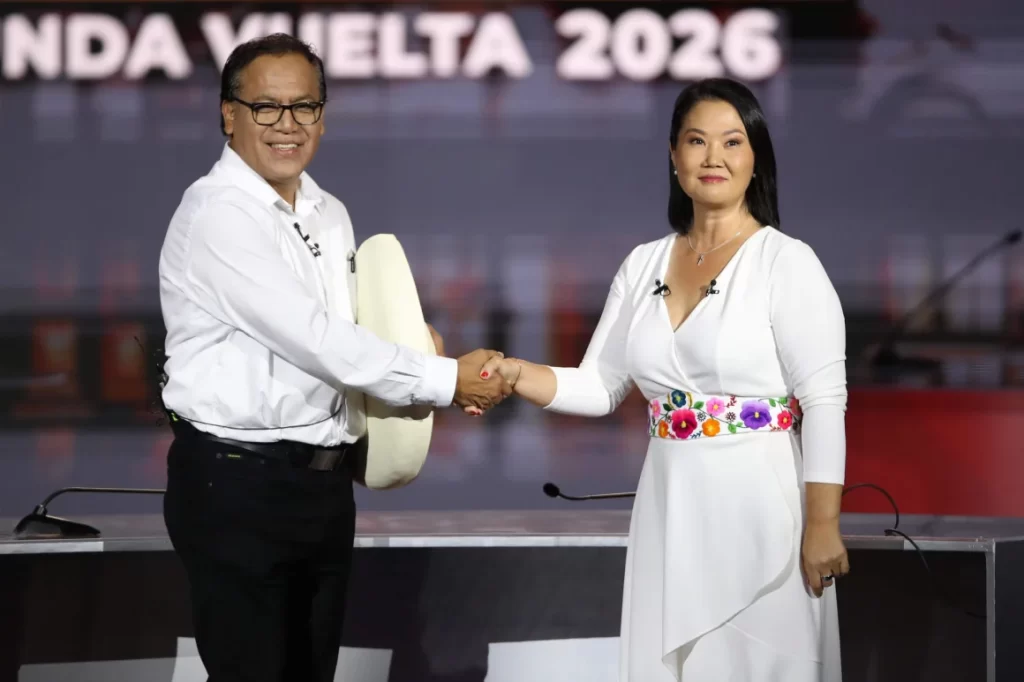 La candidata derechista Keiko Fujimori y el candidato izquierdista Roberto Sánchez se saludan durante debate presidencial.